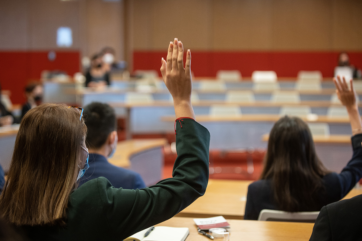 Seated students with their hands raised during 2022's Networking Trek inside Freeberg Forum.