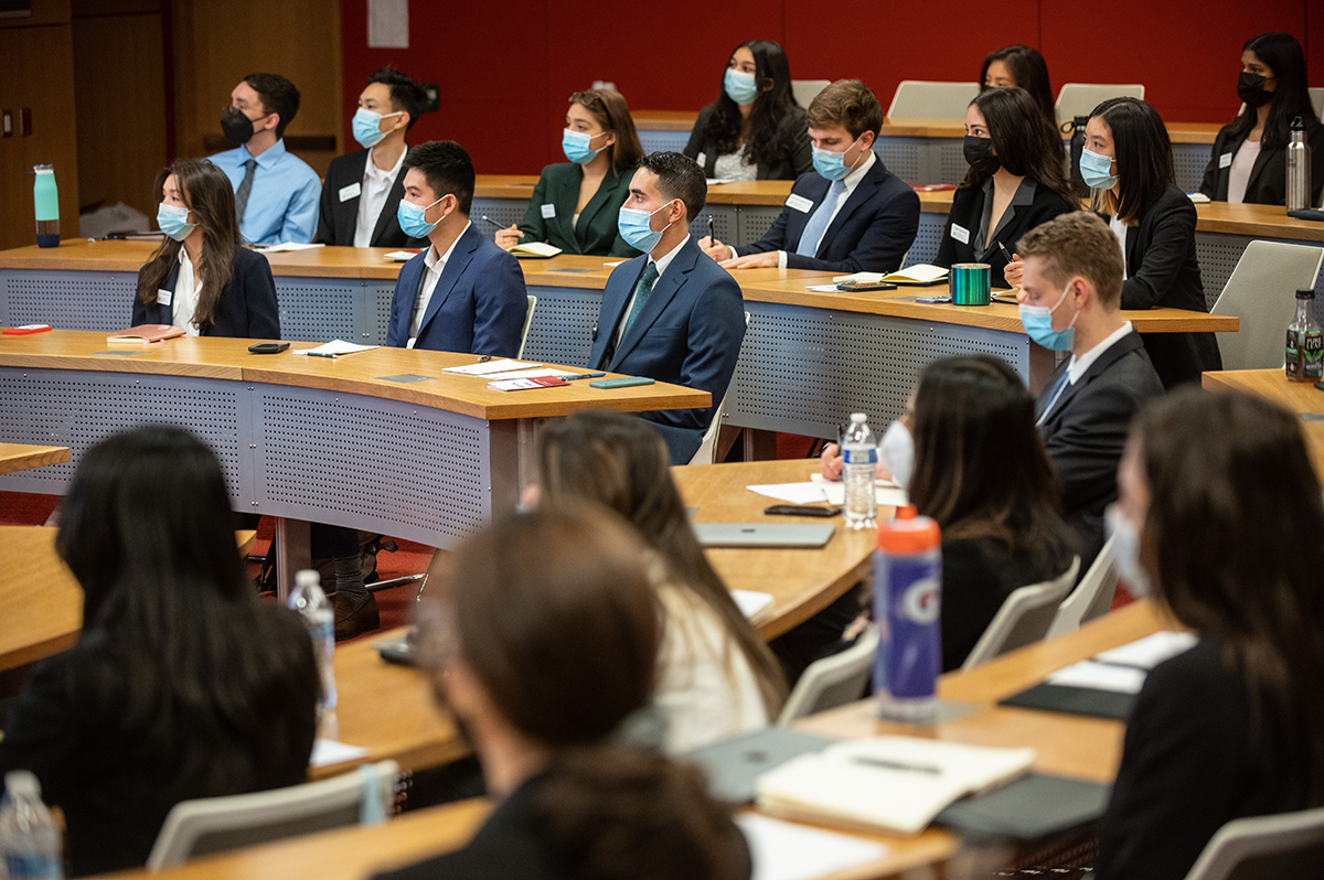 Rows of seated students in suits inside Freeberg Forum during 2022's Networking Trek.