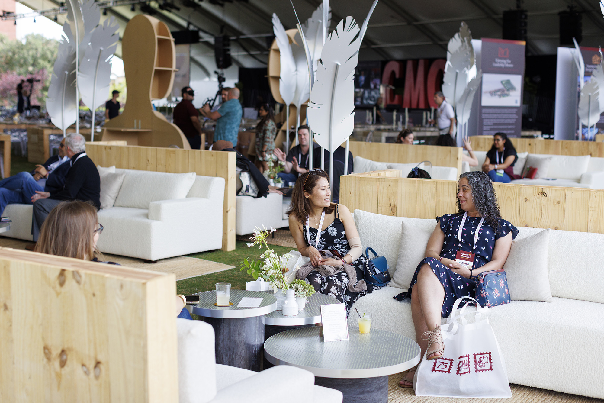 Alumni take advantage of the conversation furniture set up under the main event tent at 2022 Alumni Weekend to catch up with each other in small groups.