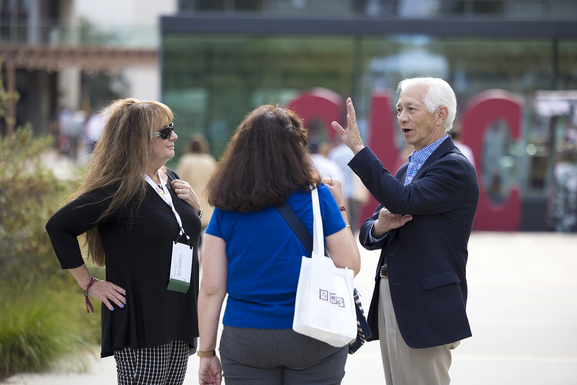 Candid photo of alumni in an animated discussion in front of the Kube and Kravis Center.