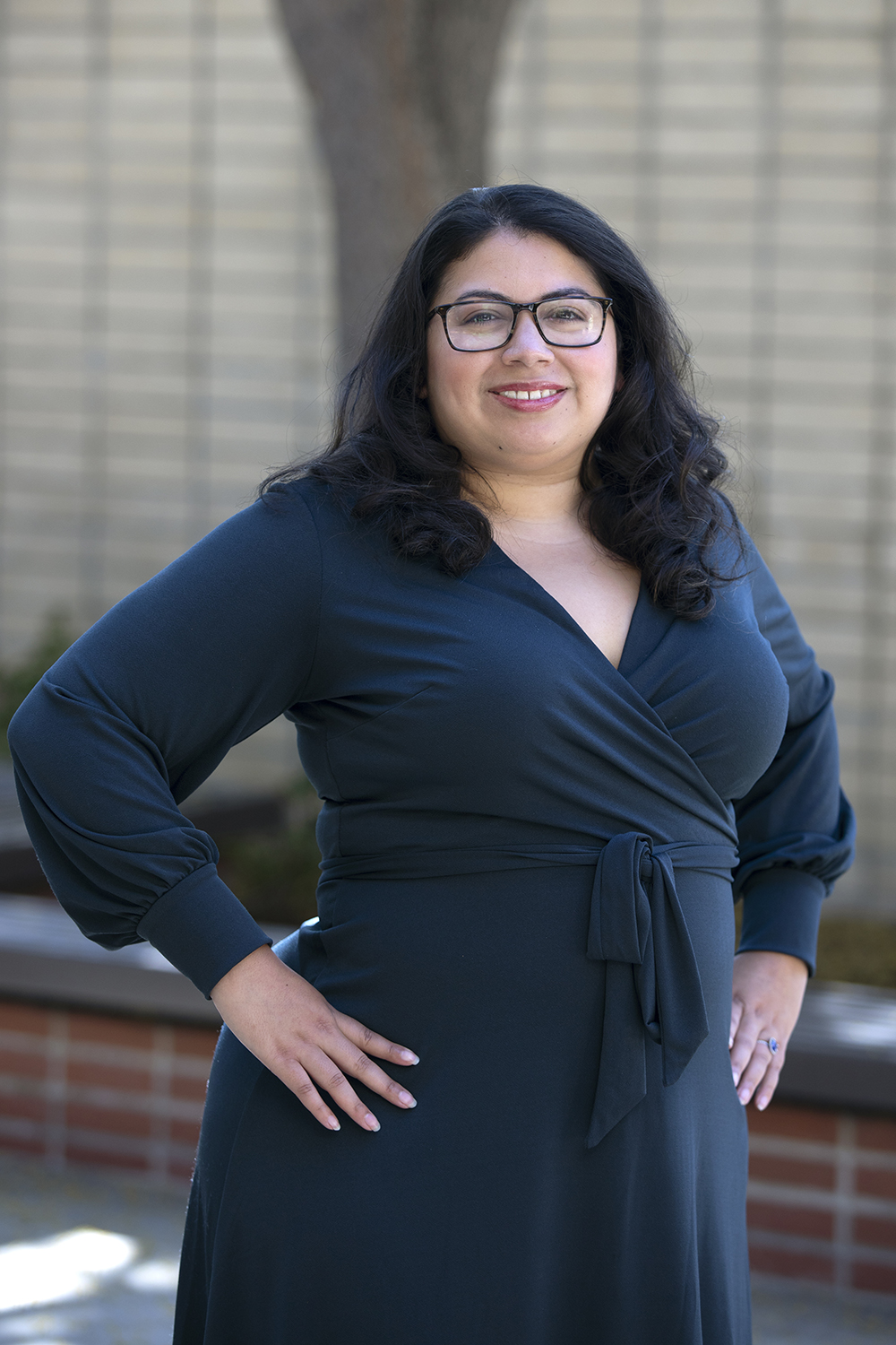 Brittany Ruiz ’08 photographed against a brick wall on campus.