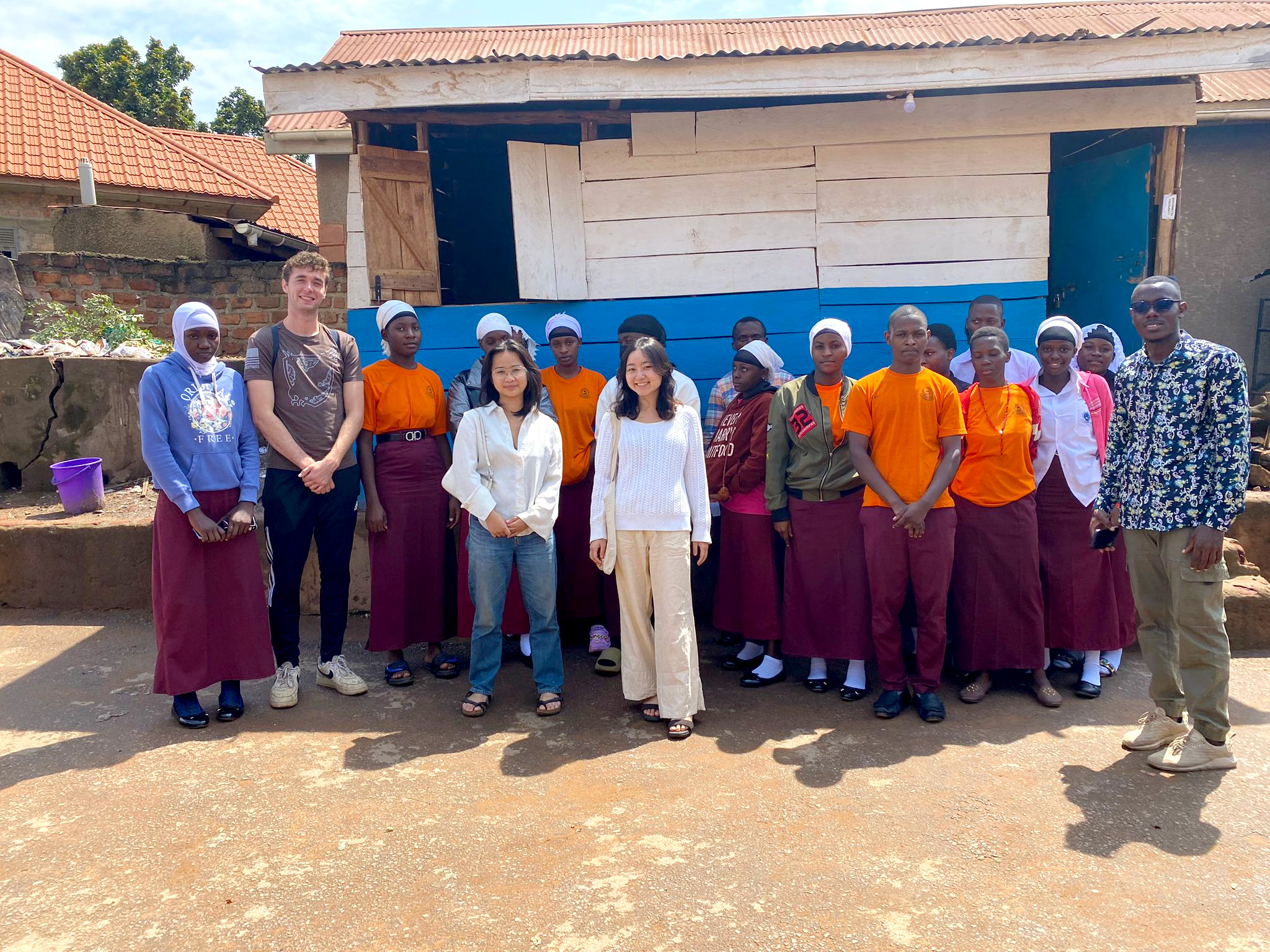 Lukas Huntington ’25, Sik Wan Poon ’26, and Yui Kurosawa ’26 visiting Queen's College, Wakiso with fellow Musizi intern Derrick Kayitale.