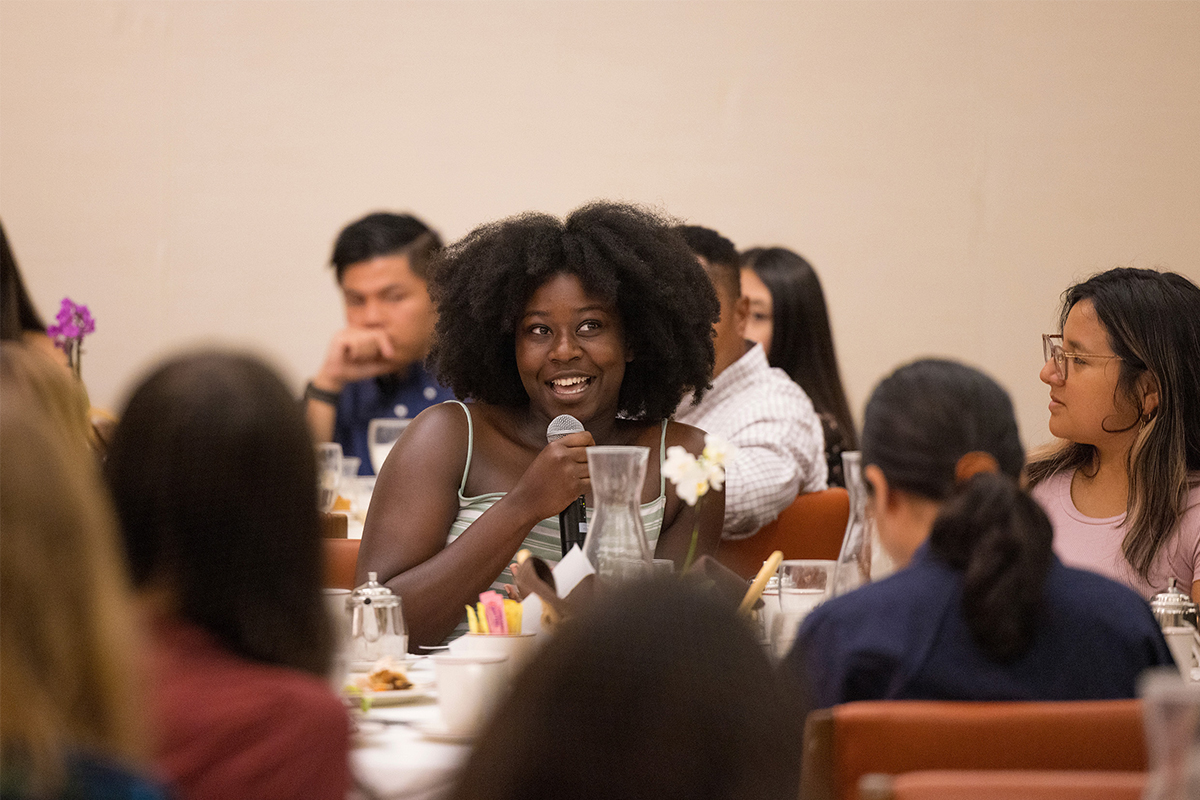 A student posing a question at one of the Open Academy's First Year and sophomore dinners.