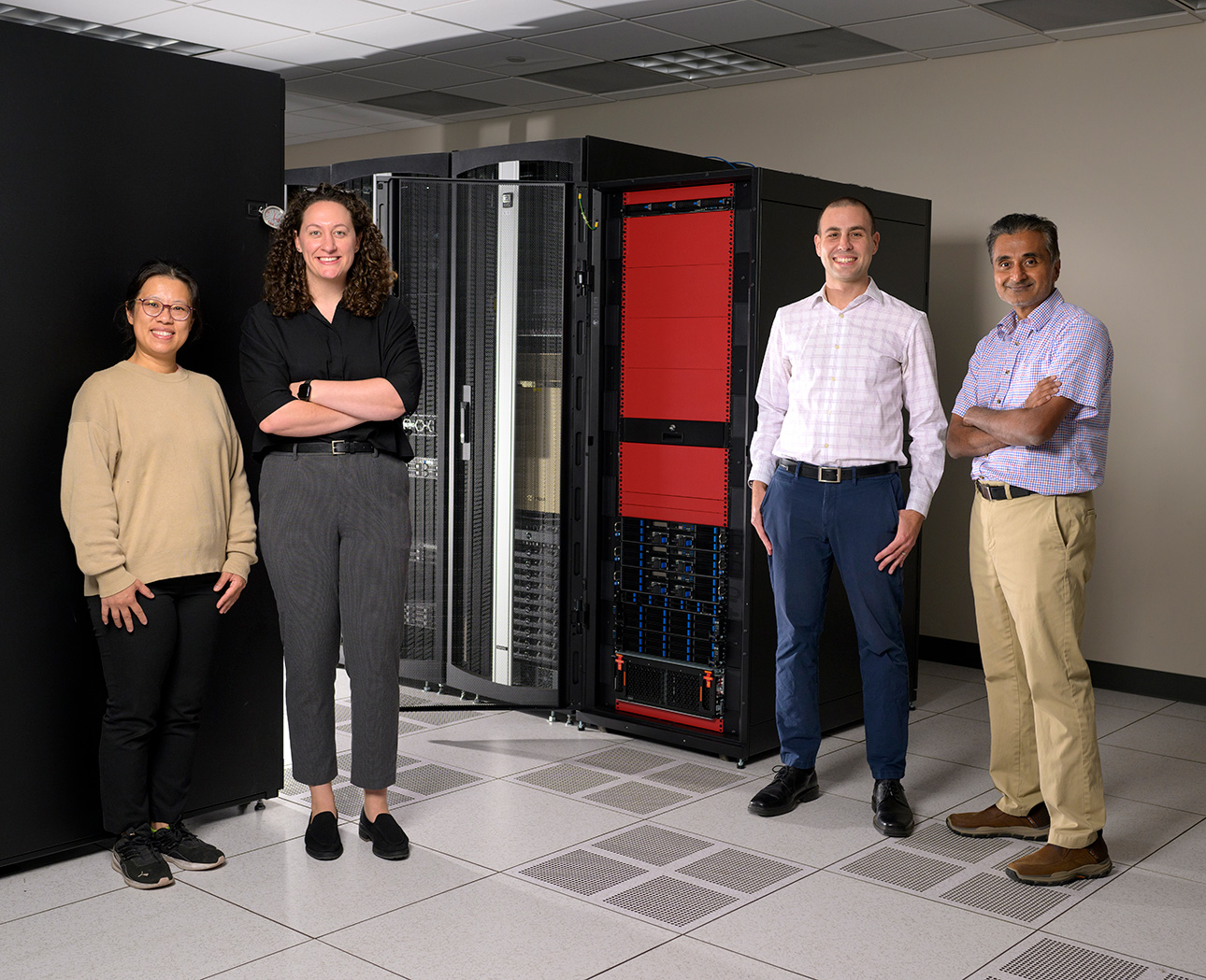 Four professors standing in front of new high-tech equipment. 