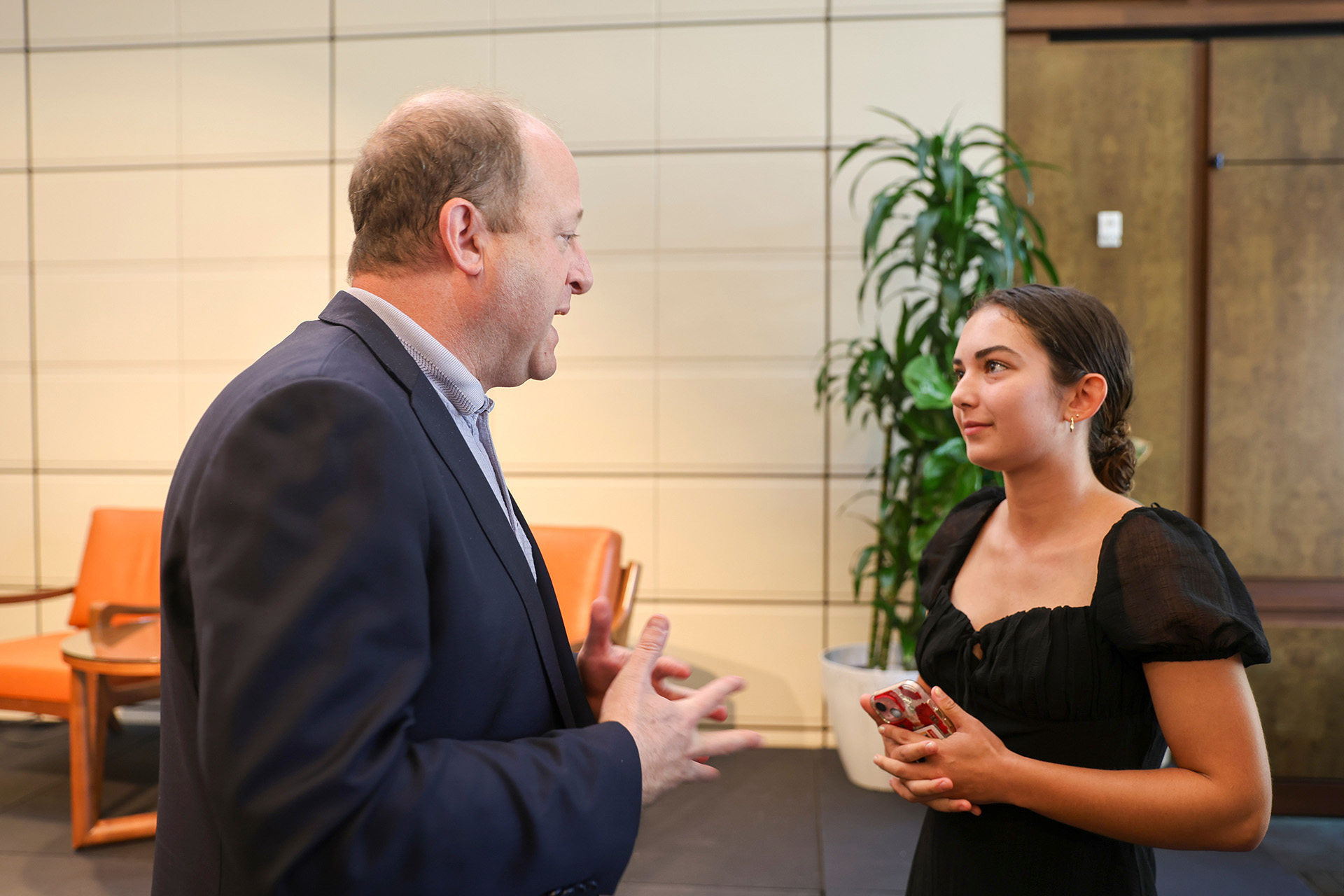 Jared Polis (left) speaking with CMC student.