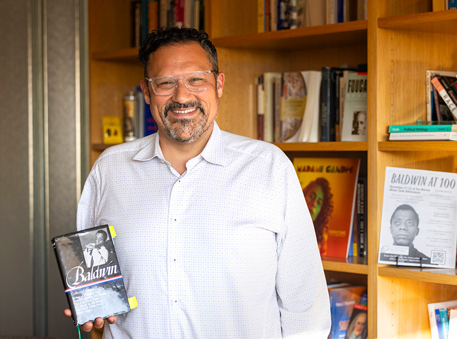 Nicholas Buccola holding a James Baldwin's book.