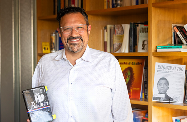 Nicholas Buccola holding a James Baldwin's book.