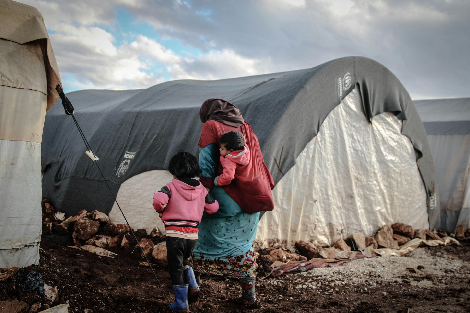 A family outside of a temporary housing structure. 