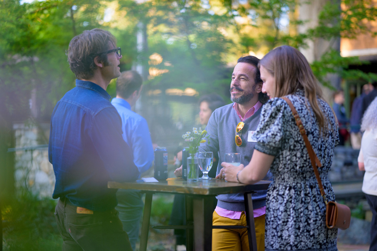 Three faculty members speaking around a high-table during faculty award reception.