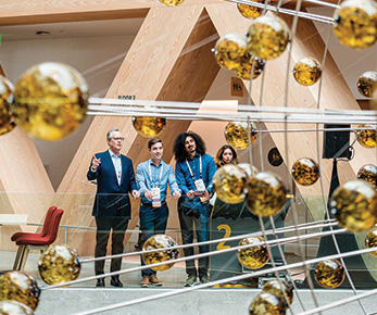 Guests look on at the Atrium, defined by the suspended Magnetic Field installation.
