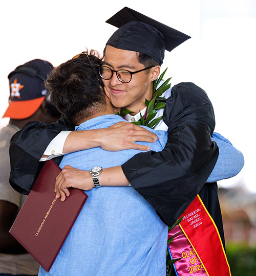 A student embraces a family member during Commencement.