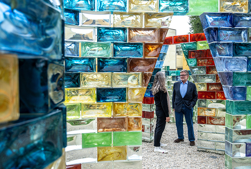 Pae White and Christopher Walker ’69 standing in the public art piece, Qwalala.