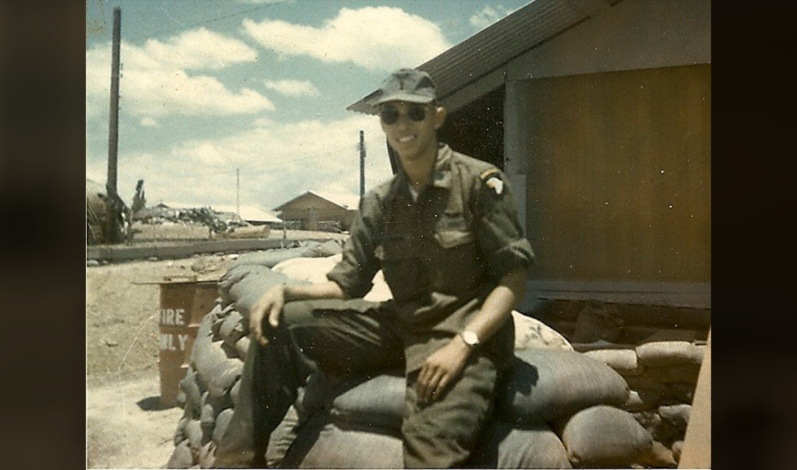 Russ as a young man in the service, seated on stacked bags of sand.