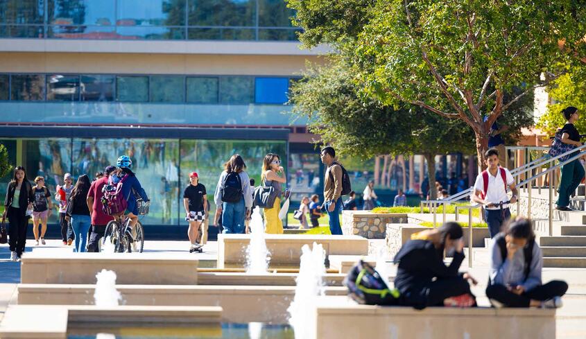 Students on campus with fountain and Kravis Center