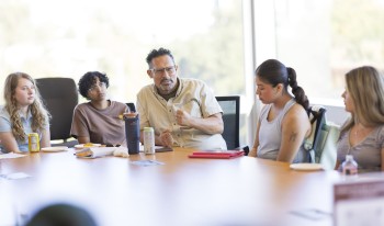Prof. Buccola at a table with students
