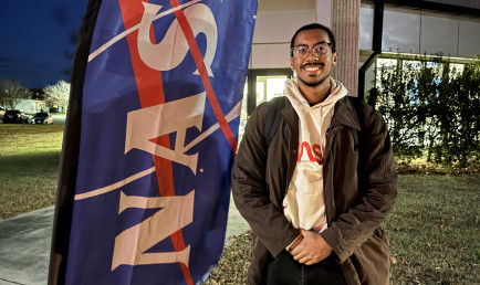 Chad McElroy standing in front of NASA sign