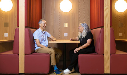 Prof. Ran Libeskind-Hadas and Prof. Heather Antecol sitting in booth at RDSC