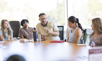 Prof. Buccola at a table with students