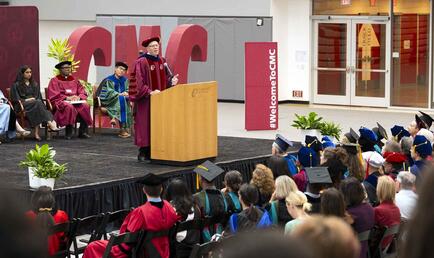 President Dudley at the podium in Roberts Pavilion during Convocation