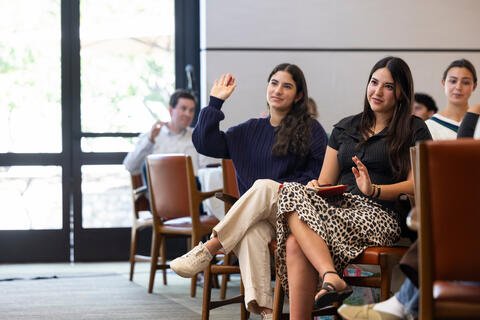 A student participant raises her hand to ask a question at 2026 Women and Leadership Alliance Conference.