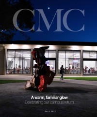 CMC Magazine photo cover for Fall 2021: Collins Dining Hall lit up at night behind one of the new Carol Bove sculptures. A student walks along the path between the glass windows with 75th Anniversary decals applied, and the sculpture. Below the sculpture is the text "A warm, familiar glow: Celebrating our campus return."