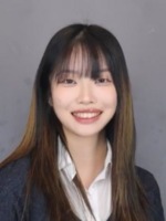 Woman with long brown hair wearing blazer and white top. 