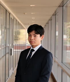 headshot of student in glass hallway