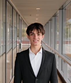 headshot of student in glass hallway