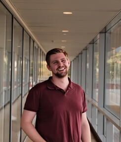headshot of student in glass hallway