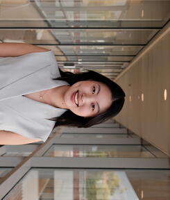 headshot of student in glass hallway