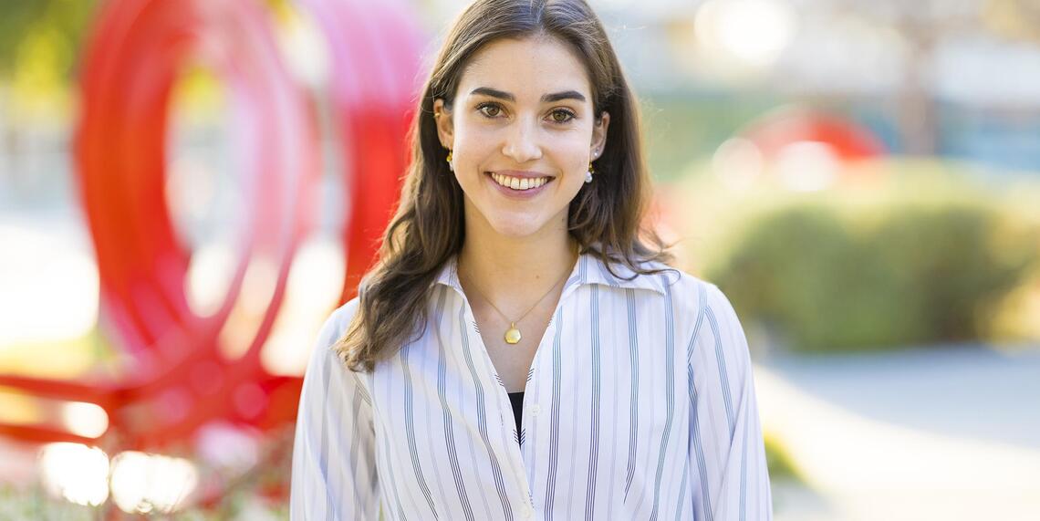 Celine Bernhardt-Lanier ’26 photographed in front of the red Jeppe Hein benches on campus.